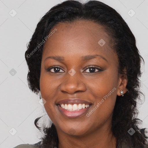 Joyful black young-adult female with long  black hair and brown eyes