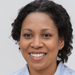 Joyful latino adult female with medium  brown hair and brown eyes