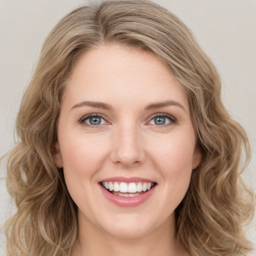 Joyful white young-adult female with long  brown hair and green eyes