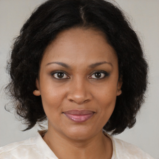 Joyful black young-adult female with medium  brown hair and brown eyes
