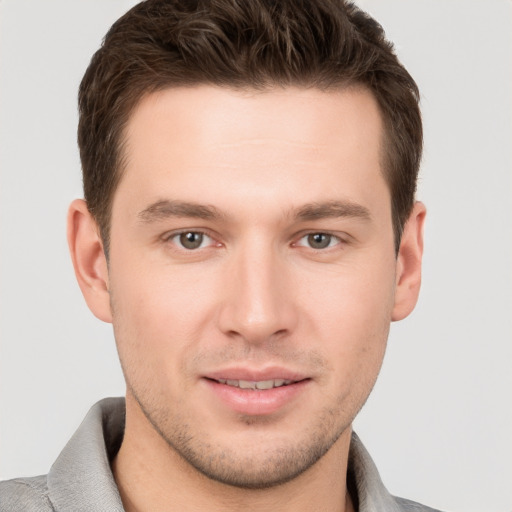 Joyful white young-adult male with short  brown hair and grey eyes