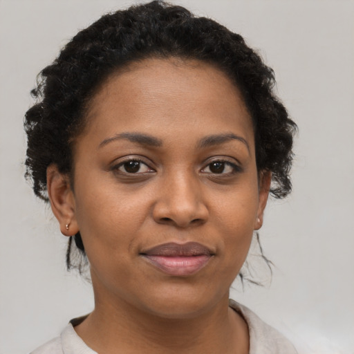 Joyful black young-adult female with short  brown hair and brown eyes
