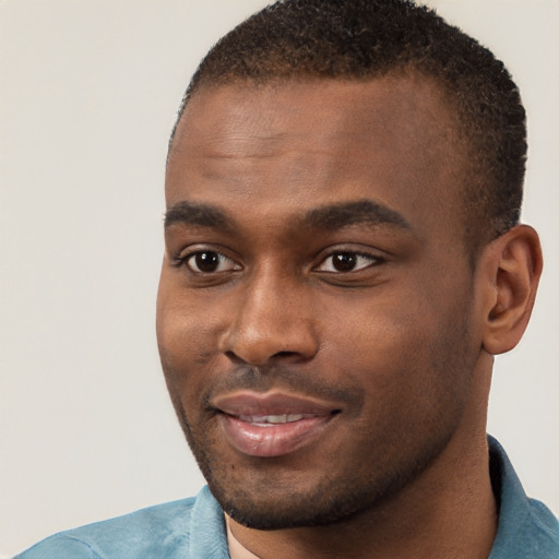 Joyful black young-adult male with short  brown hair and brown eyes