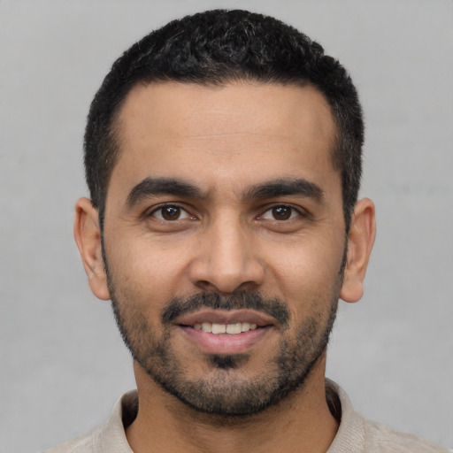 Joyful latino young-adult male with short  black hair and brown eyes