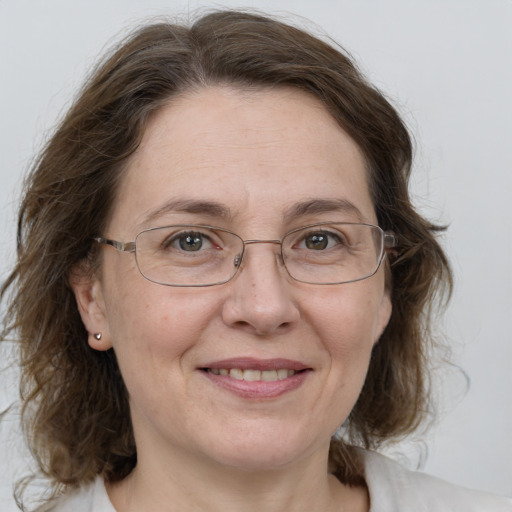 Joyful white adult female with medium  brown hair and grey eyes