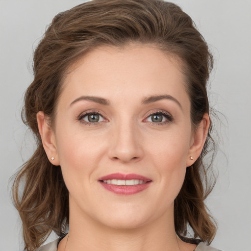 Joyful white young-adult female with medium  brown hair and grey eyes