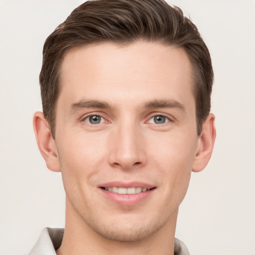 Joyful white young-adult male with short  brown hair and grey eyes