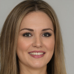 Joyful white young-adult female with long  brown hair and brown eyes