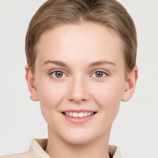 Joyful white young-adult female with short  brown hair and grey eyes