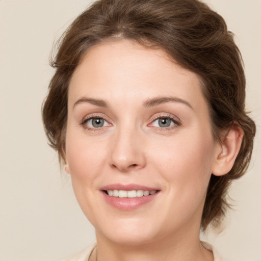 Joyful white young-adult female with medium  brown hair and green eyes