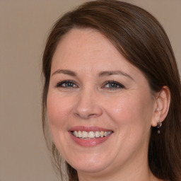 Joyful white adult female with long  brown hair and brown eyes