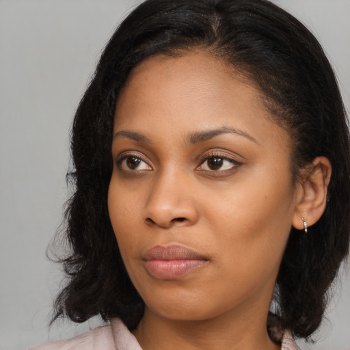 Joyful black young-adult female with long  brown hair and brown eyes