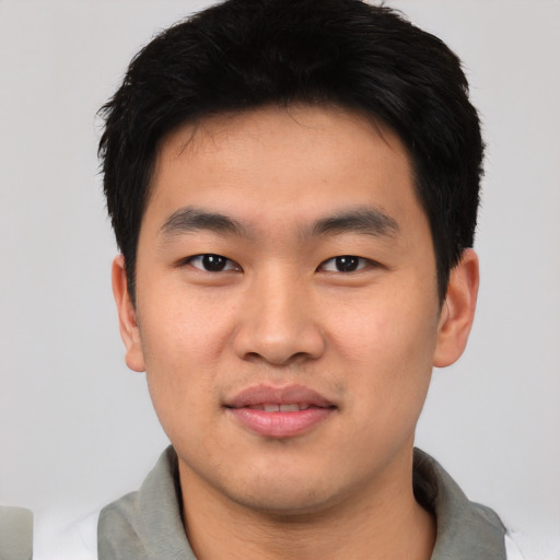 Joyful asian young-adult male with short  black hair and brown eyes