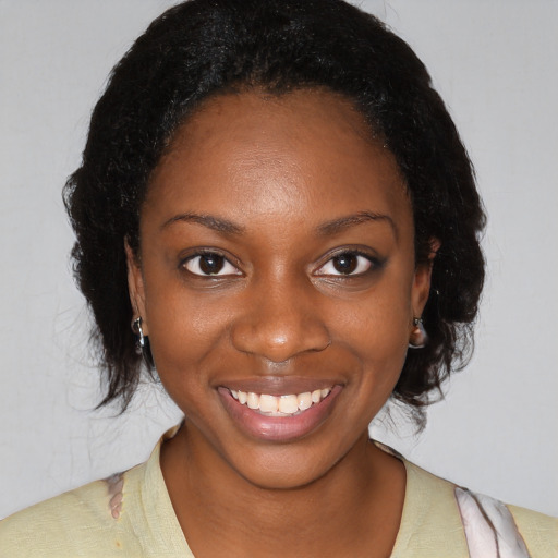Joyful black young-adult female with medium  brown hair and brown eyes
