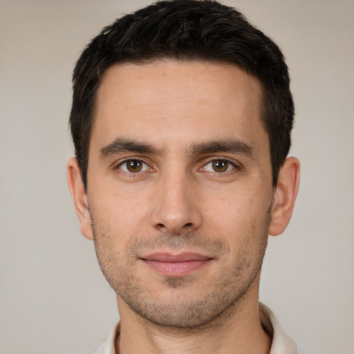 Joyful white young-adult male with short  black hair and brown eyes