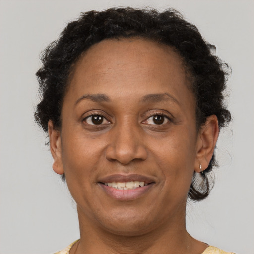 Joyful black adult female with short  brown hair and brown eyes