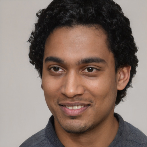 Joyful black young-adult male with short  black hair and brown eyes