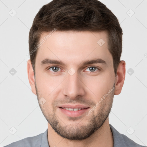 Joyful white young-adult male with short  brown hair and grey eyes