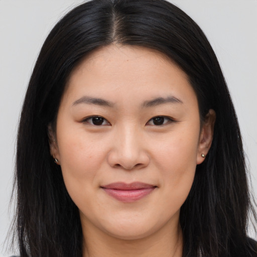 Joyful asian young-adult female with long  brown hair and brown eyes