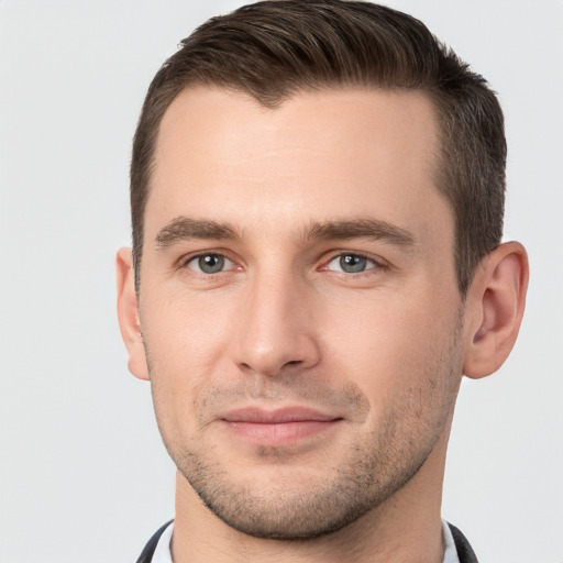 Joyful white young-adult male with short  brown hair and grey eyes