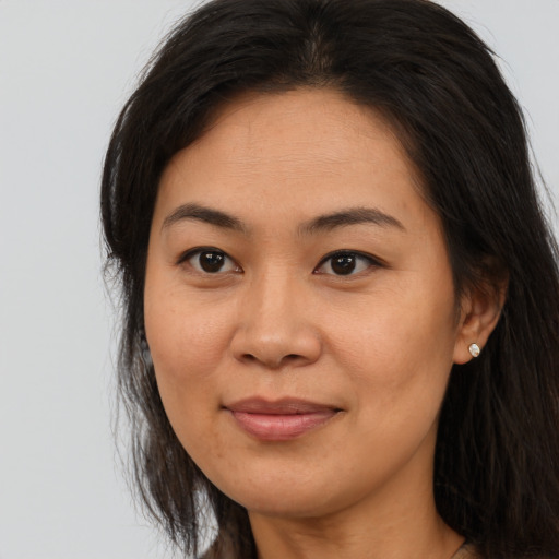 Joyful asian adult female with long  brown hair and brown eyes