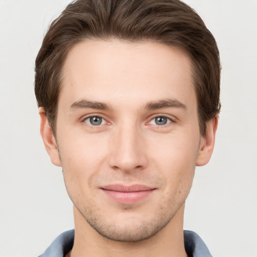 Joyful white young-adult male with short  brown hair and grey eyes