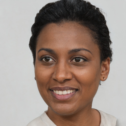 Joyful black young-adult female with short  black hair and brown eyes