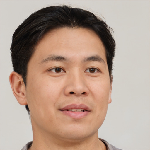 Joyful asian adult male with short  brown hair and brown eyes