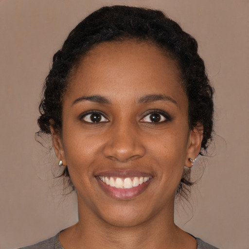 Joyful black young-adult female with medium  brown hair and brown eyes
