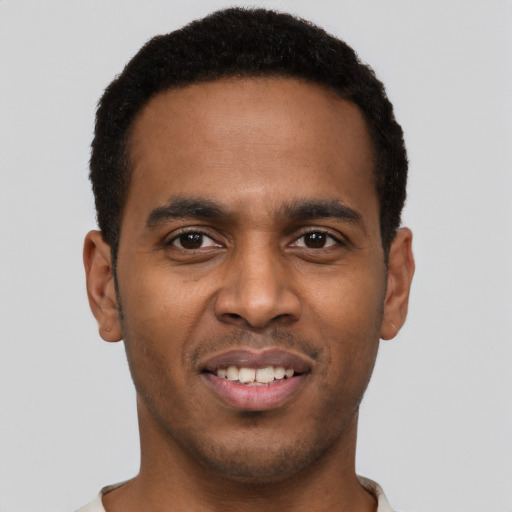Joyful black young-adult male with short  black hair and brown eyes