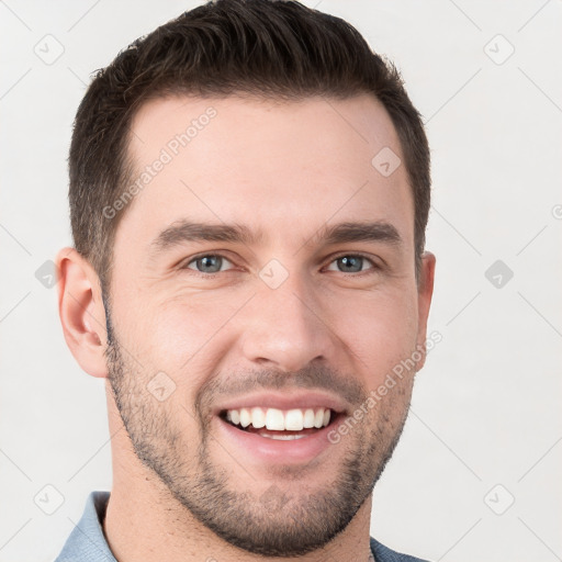 Joyful white young-adult male with short  brown hair and grey eyes