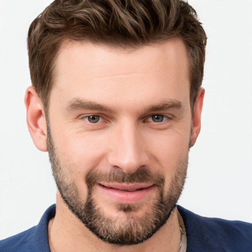 Joyful white young-adult male with short  brown hair and grey eyes