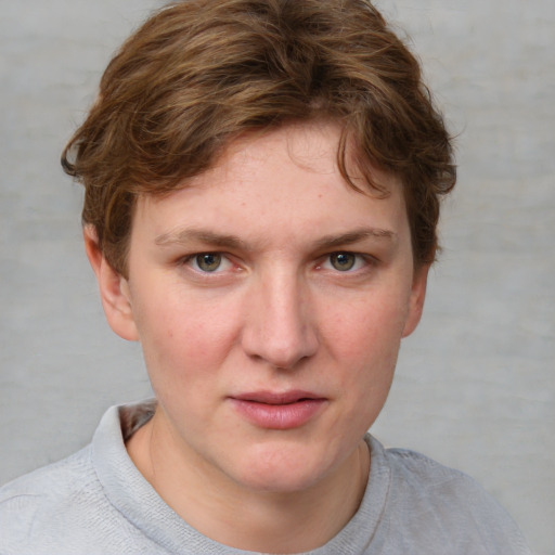 Joyful white young-adult female with short  brown hair and blue eyes