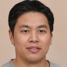 Joyful asian young-adult male with short  brown hair and brown eyes