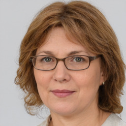 Joyful white adult female with medium  brown hair and blue eyes