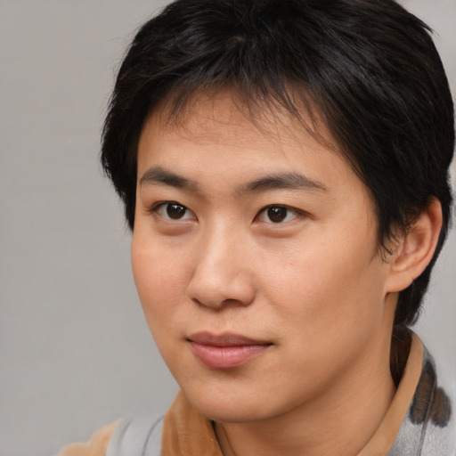 Joyful asian young-adult male with medium  brown hair and brown eyes