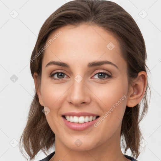 Joyful white young-adult female with medium  brown hair and grey eyes