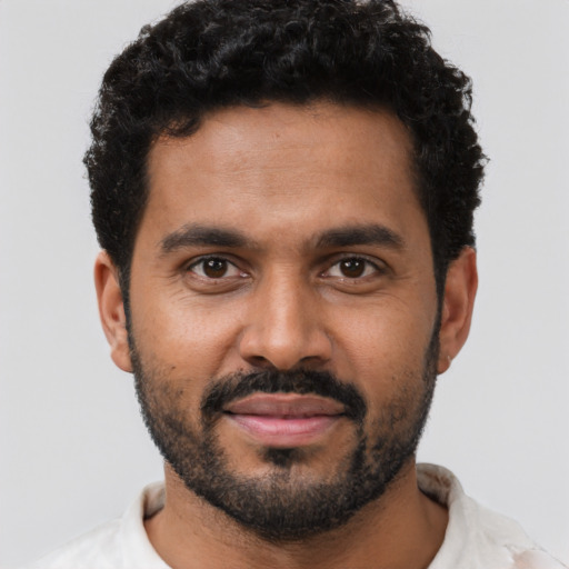 Joyful black young-adult male with short  black hair and brown eyes