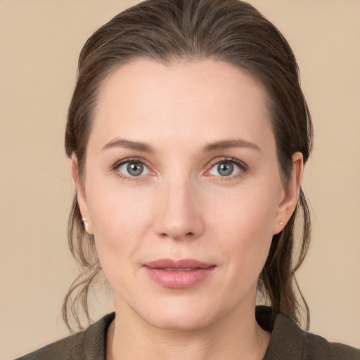 Joyful white young-adult female with medium  brown hair and grey eyes