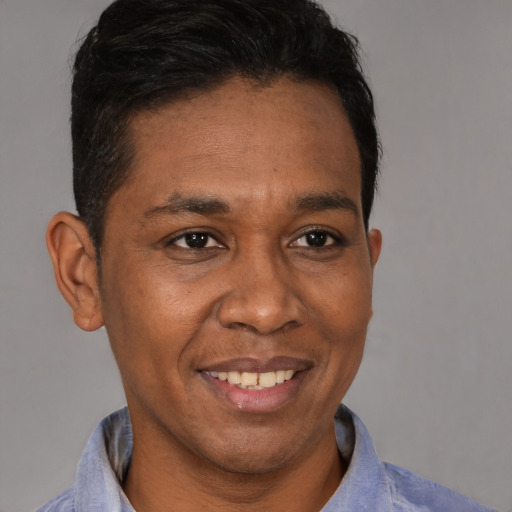 Joyful black young-adult male with short  brown hair and brown eyes