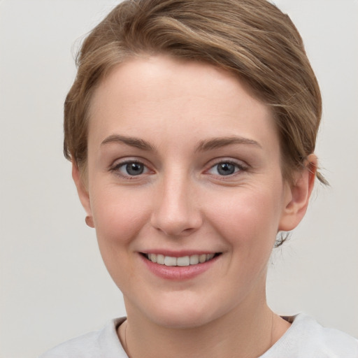 Joyful white young-adult female with short  brown hair and grey eyes