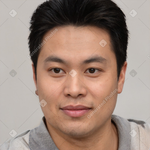 Joyful asian young-adult male with short  black hair and brown eyes