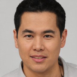 Joyful asian young-adult male with short  black hair and brown eyes