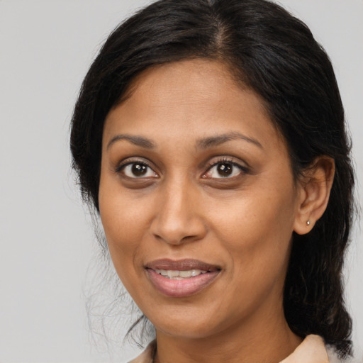 Joyful black adult female with medium  brown hair and brown eyes