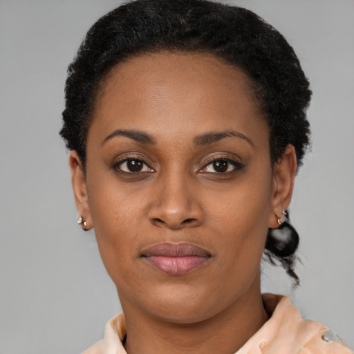 Joyful black young-adult female with short  black hair and brown eyes