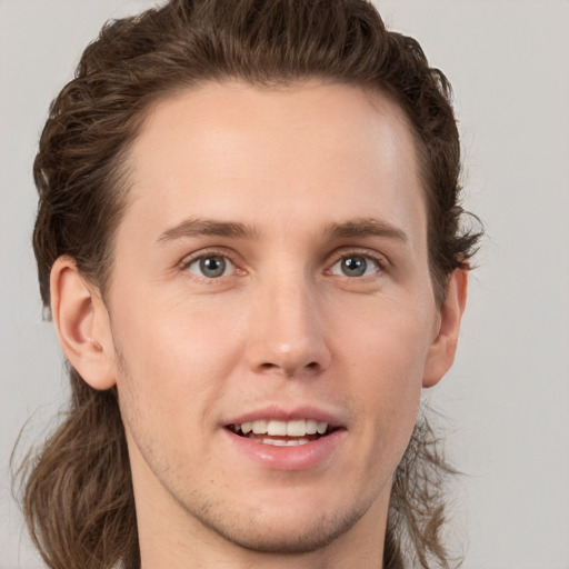 Joyful white young-adult male with short  brown hair and grey eyes