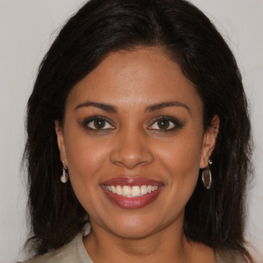 Joyful black young-adult female with long  brown hair and brown eyes