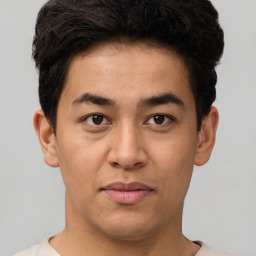 Joyful latino young-adult male with short  brown hair and brown eyes