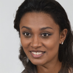 Joyful black young-adult female with long  brown hair and brown eyes