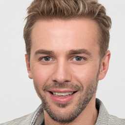 Joyful white young-adult male with short  brown hair and grey eyes